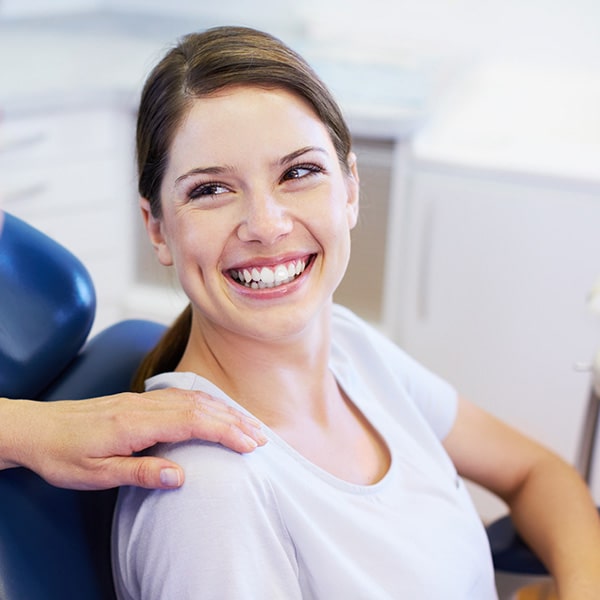 A female patient looking happy at the dentist